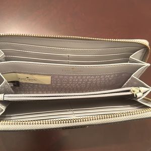 Light grey Kate Spade zip around continental wallet.